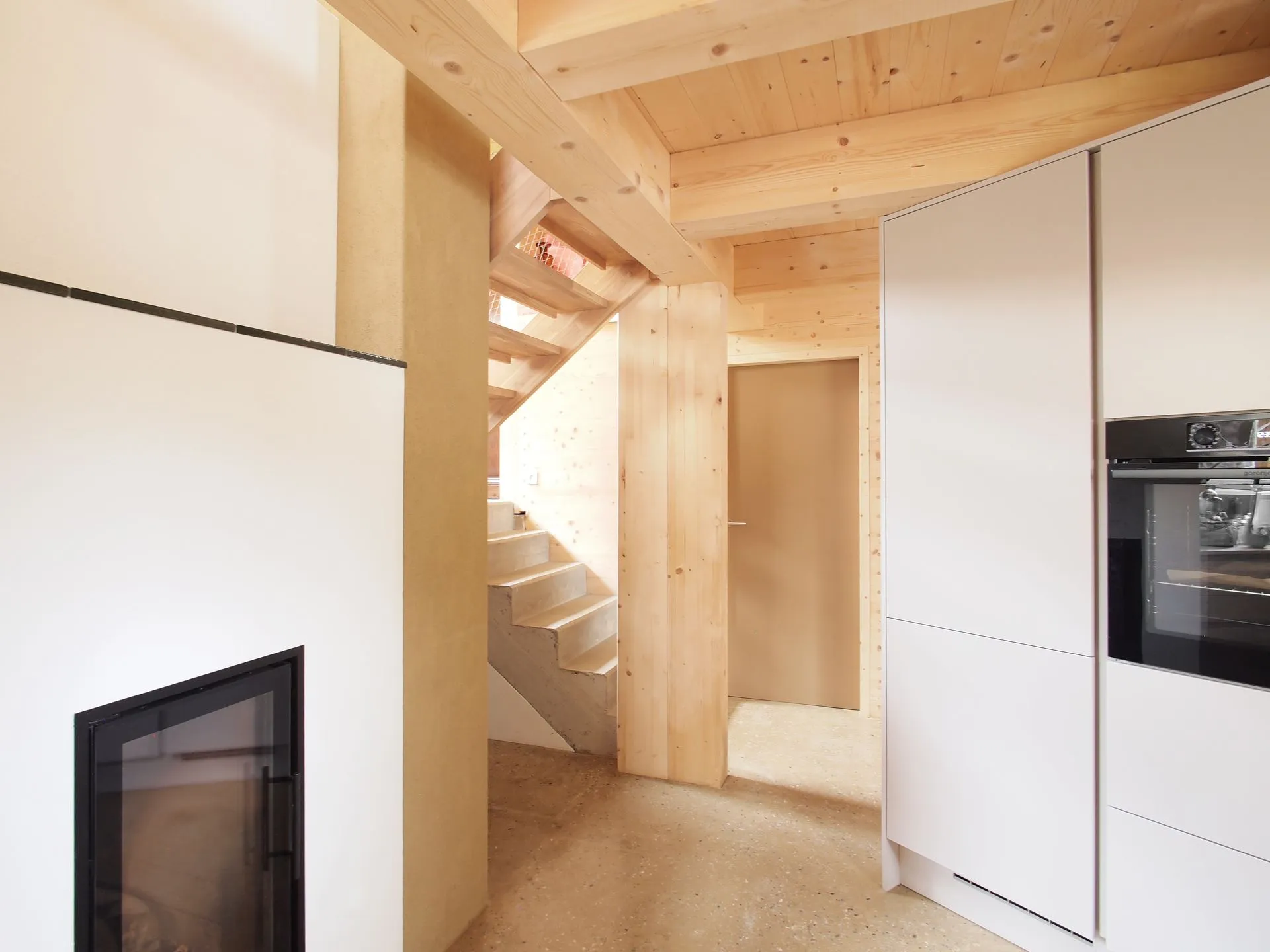 Doppelhaus Kolbetergasse - Wohnbereich mit Kamin, Holzbalken und Treppe